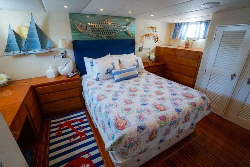 a bedroom with a bed and a dresser aboard MOMMA BEAR Yacht for Sale