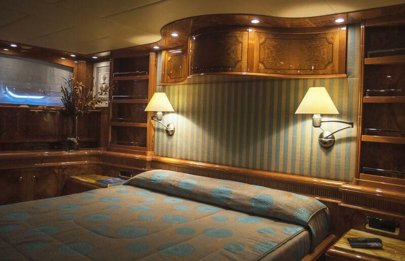 a bedroom with a bed and a lamp aboard KIRIOS Yacht for Sale