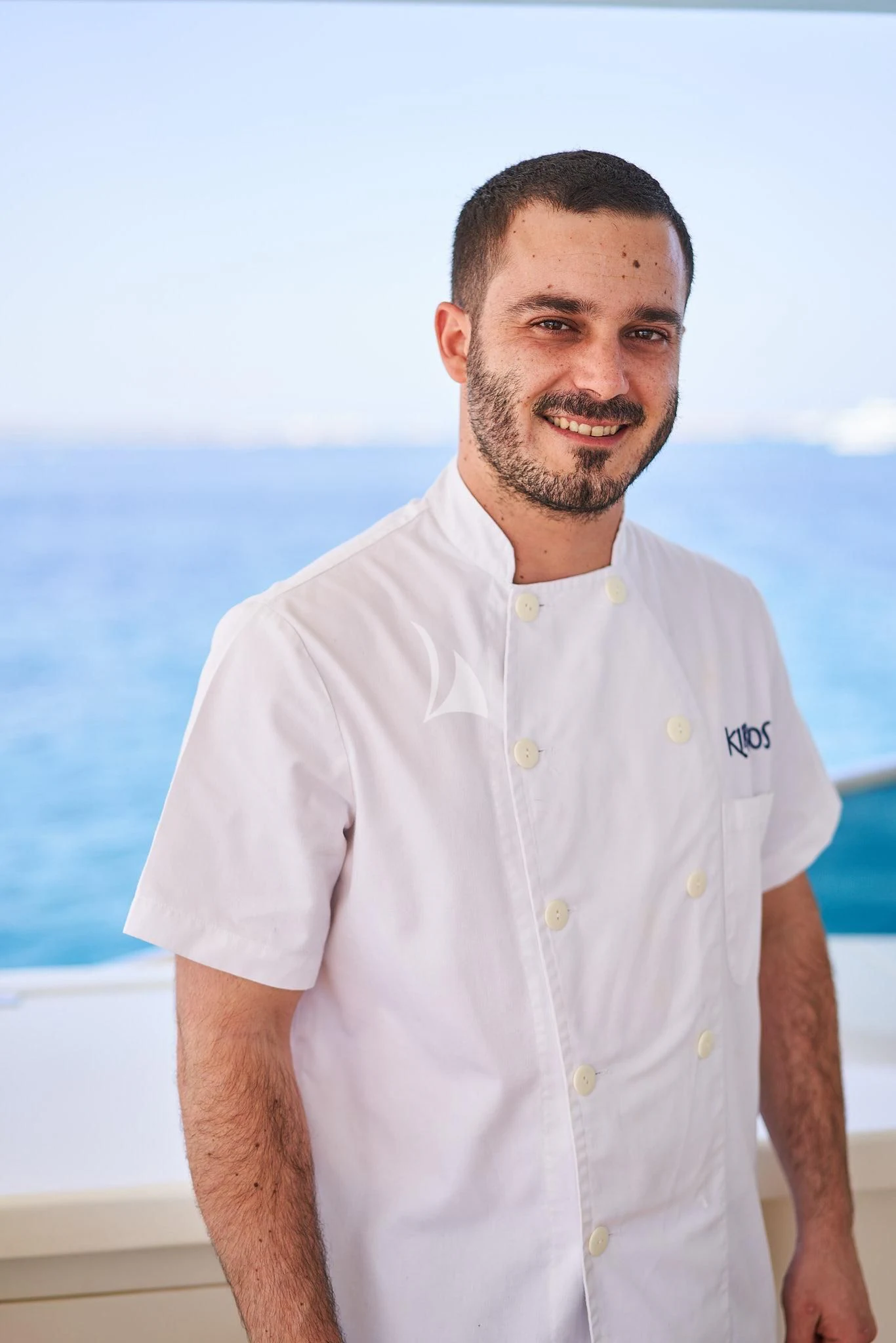 a man standing in front of a body of water aboard KIRIOS Yacht for Sale
