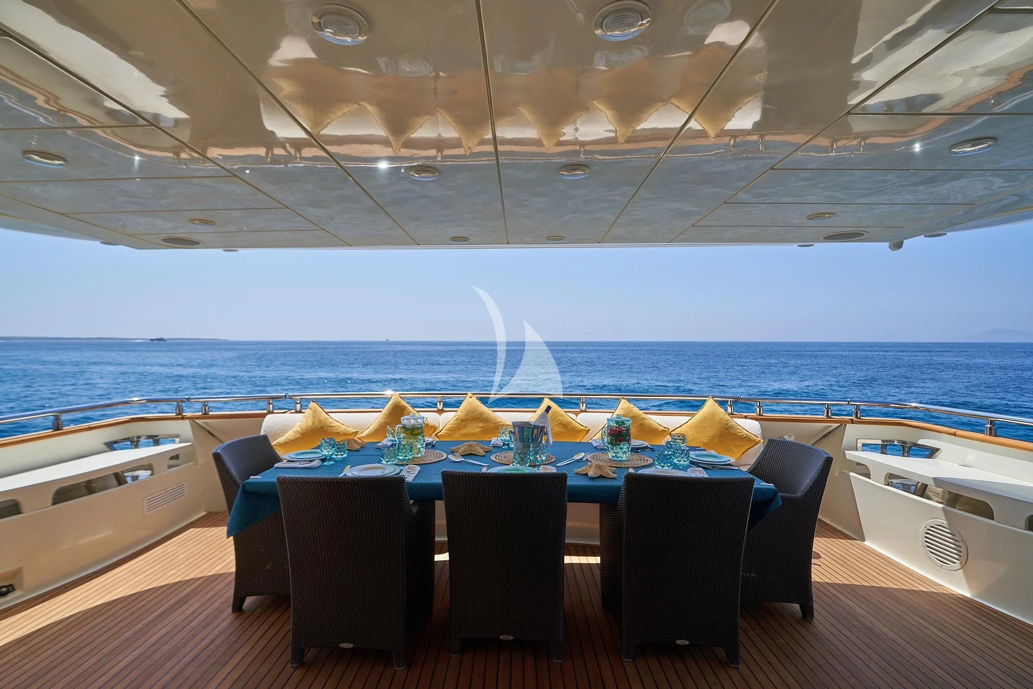 a table with chairs and a view of the ocean aboard KIRIOS Yacht for Sale