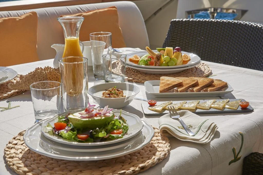 a table with food and plates of food on it aboard KIRIOS Yacht for Sale