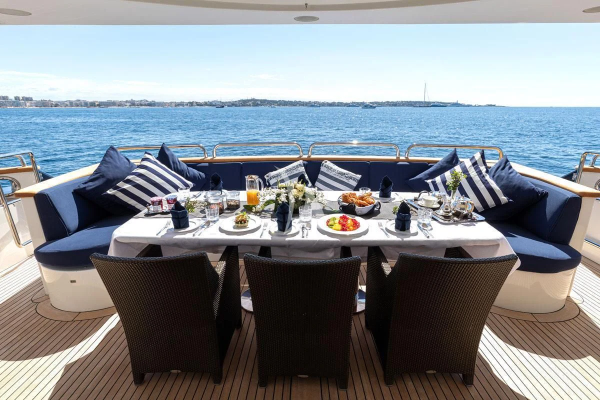 a table set for a meal on a deck overlooking the ocean aboard SEA BLUEZ Yacht for Charter