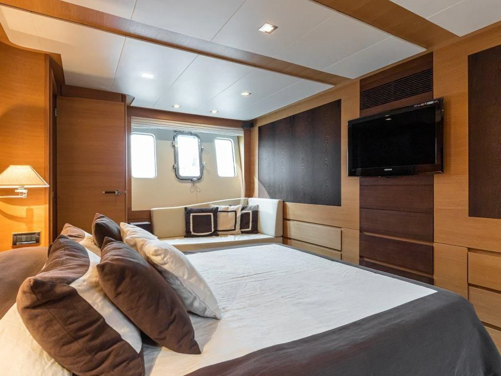 a bedroom with a bed and a television aboard PASSION Yacht for Sale