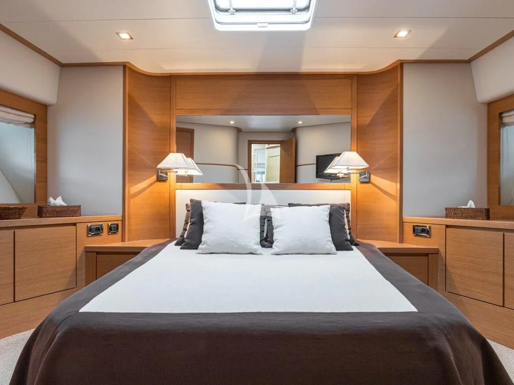 a bed with a white sheet and pillows aboard PASSION Yacht for Sale