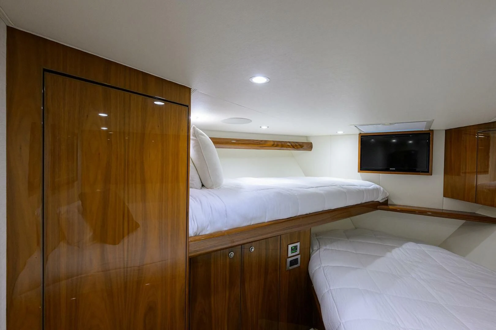 a bedroom with a tv and a bed aboard TEAM MAYHEM Yacht for Sale