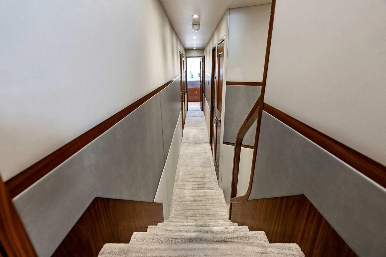 a long hallway with a staircase aboard TEAM MAYHEM Yacht for Sale