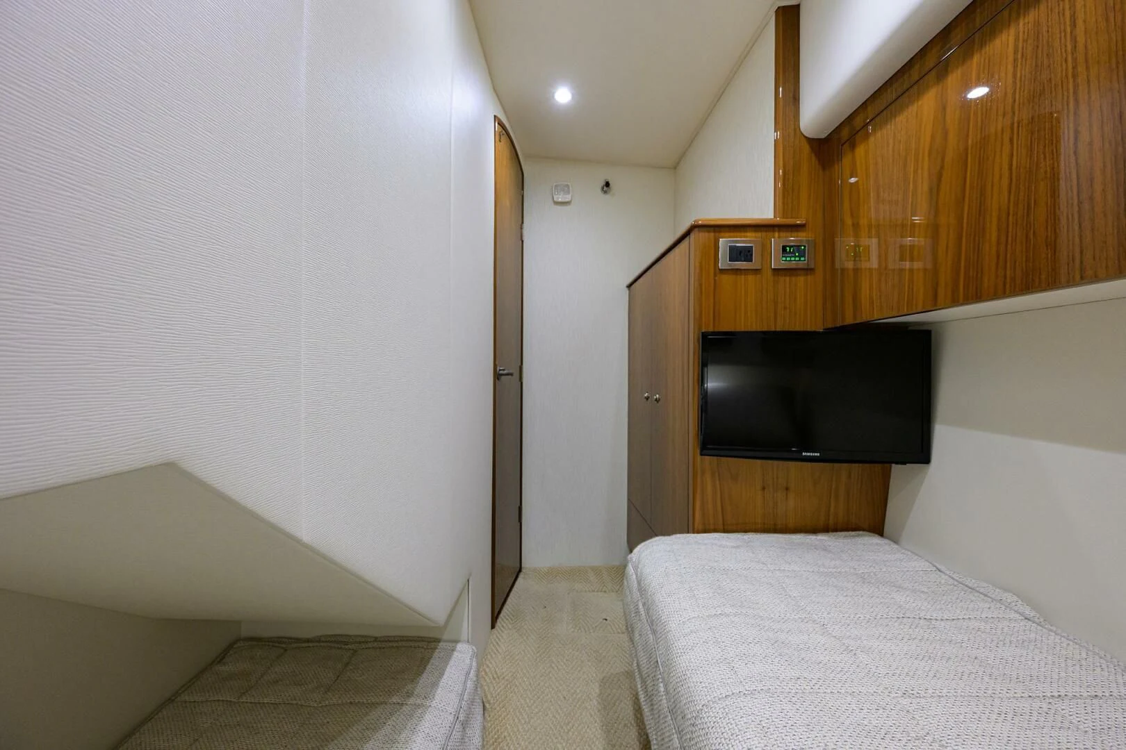 a bedroom with a tv and a bed aboard TEAM MAYHEM Yacht for Sale