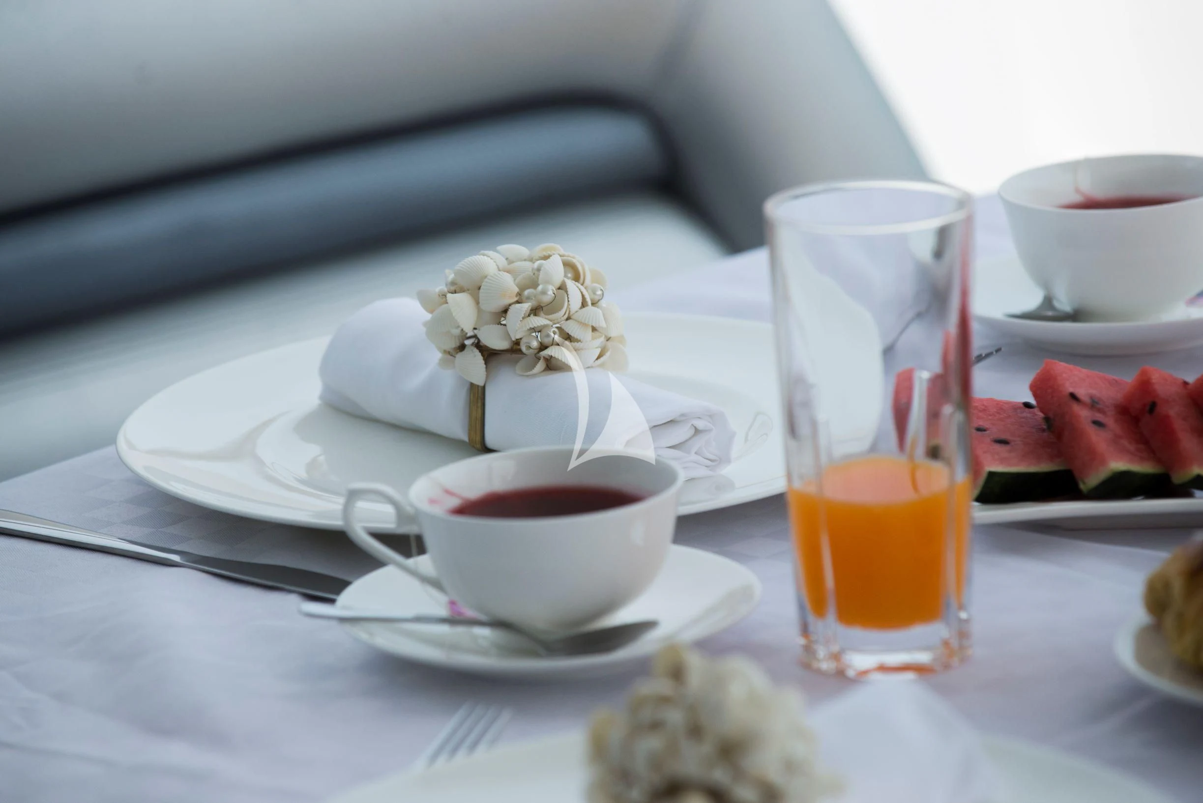 a cup of tea and a glass of tea on a table aboard LIGHT BLUE Yacht for Sale