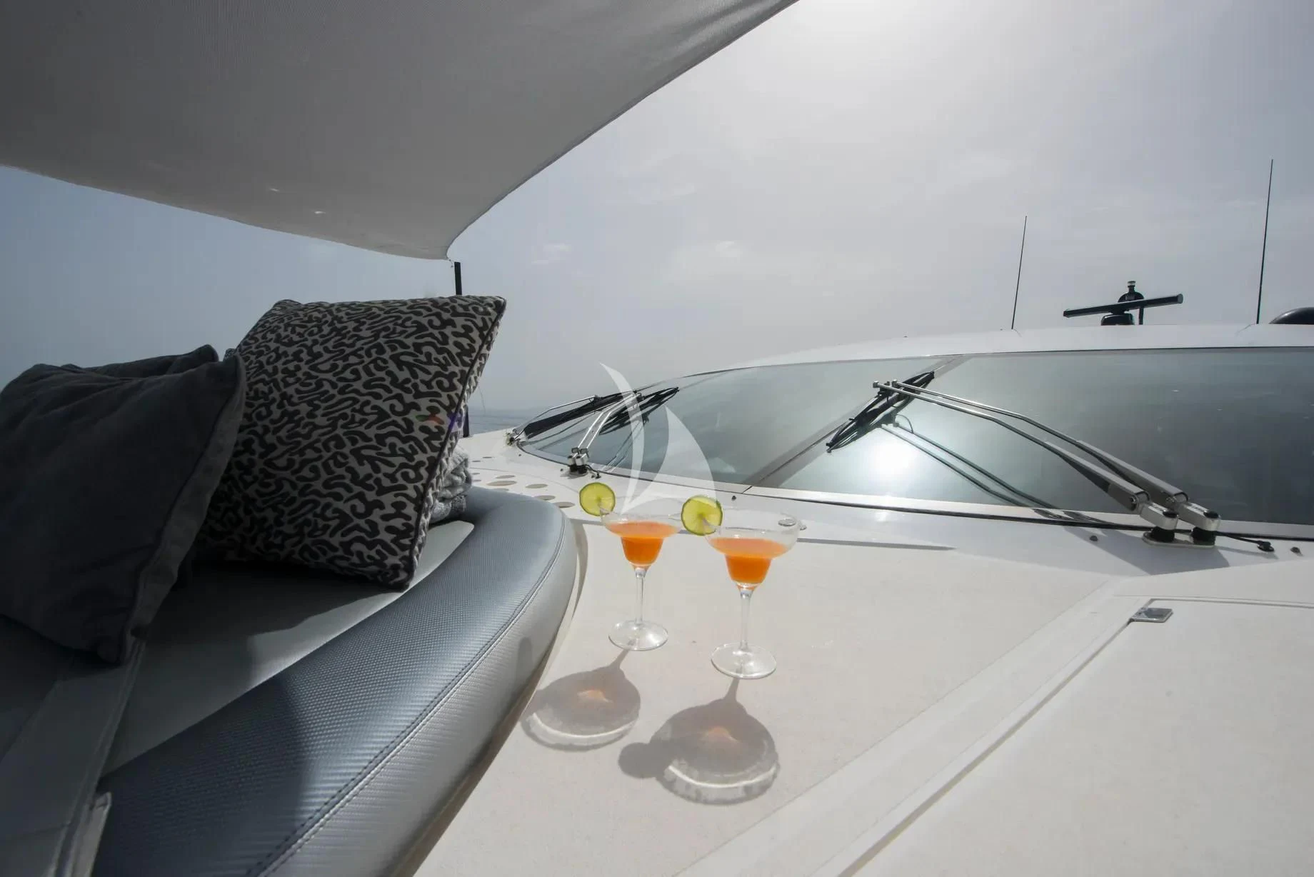 a table with glasses and a couch aboard LIGHT BLUE Yacht for Sale