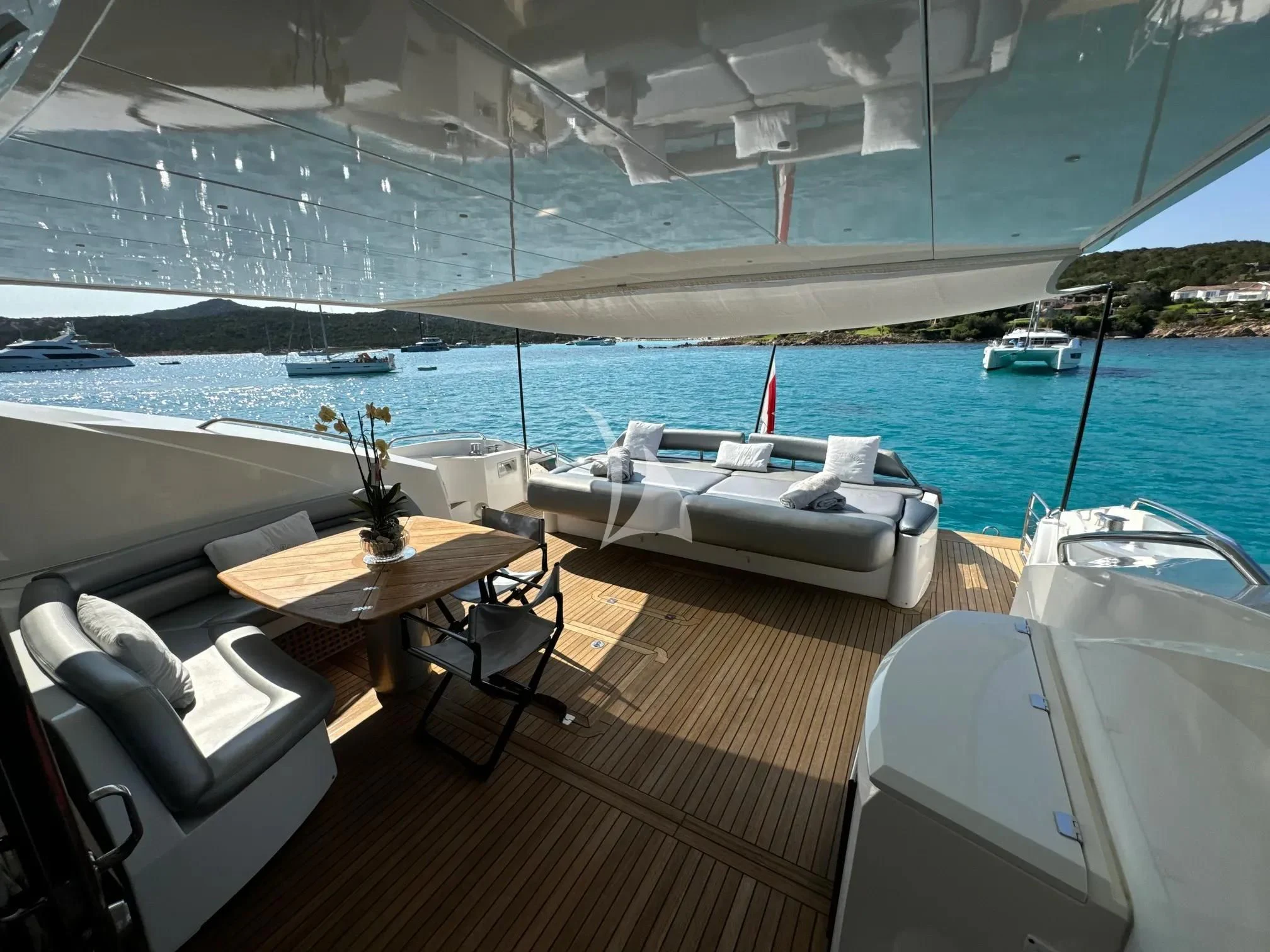 a room with a table and chairs on a deck overlooking a body of water aboard LIGHT BLUE Yacht for Sale
