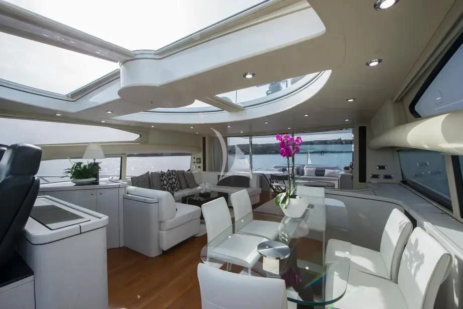 a room with a large window and a table with chairs and a plant on it aboard LIGHT BLUE Yacht for Sale