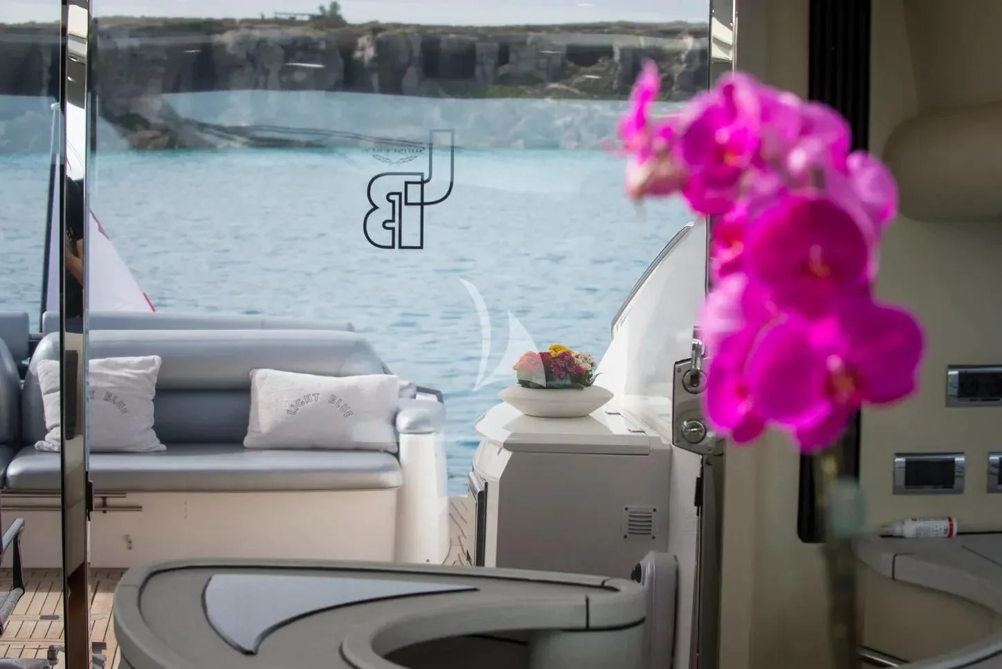 a white bed with pink flowers on it aboard LIGHT BLUE Yacht for Sale