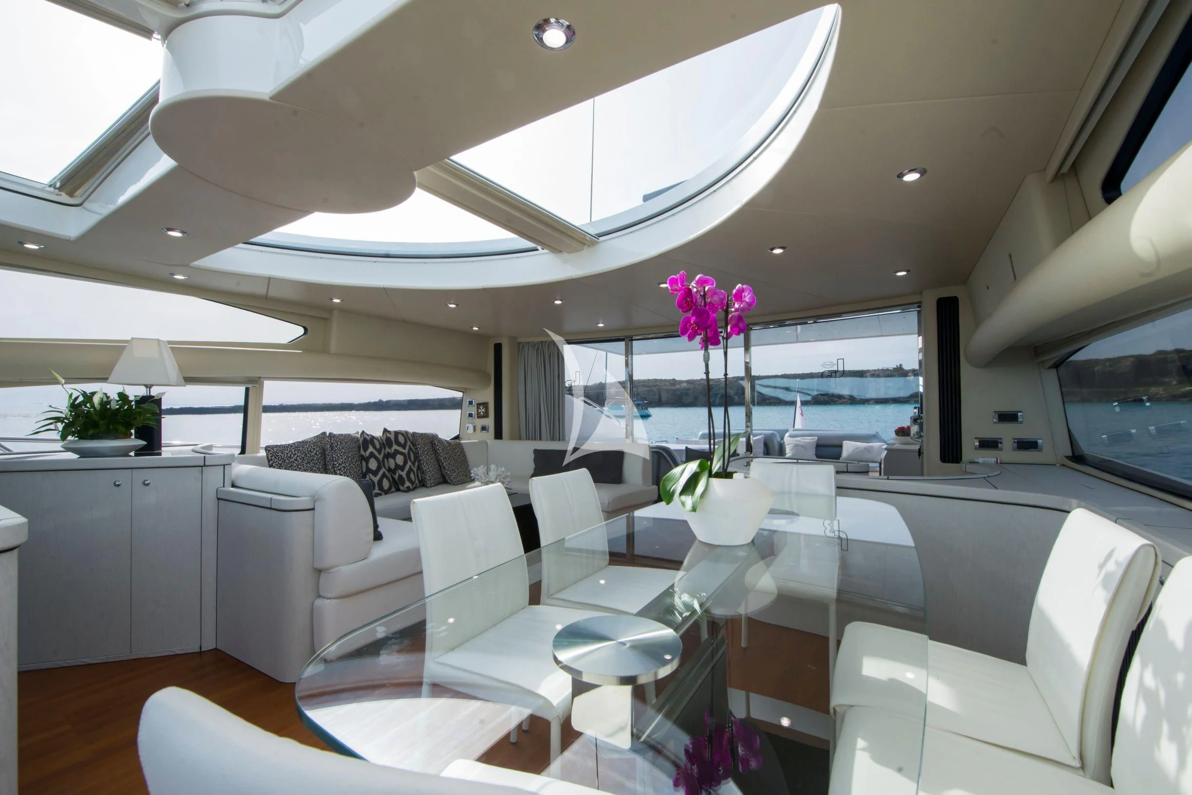 a room with a couch and a table with chairs aboard LIGHT BLUE Yacht for Sale