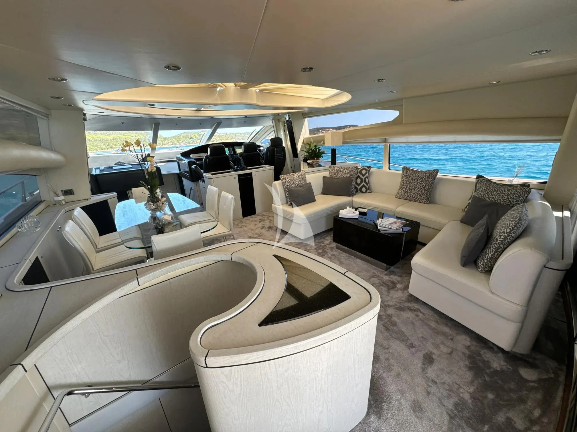 a living room with a large white sofa and a large open umbrella aboard LIGHT BLUE Yacht for Sale