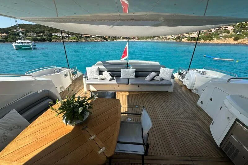 a deck with a table and chairs on it by a body of water aboard LIGHT BLUE Yacht for Sale