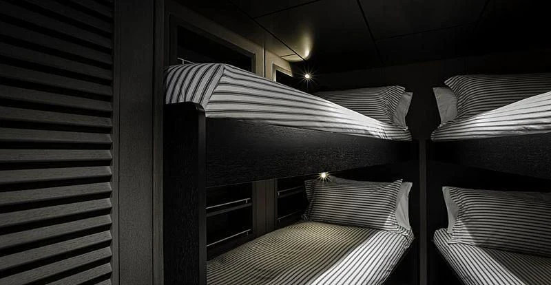 a room with a bed and a striped pillow aboard THE BEAST Yacht for Sale