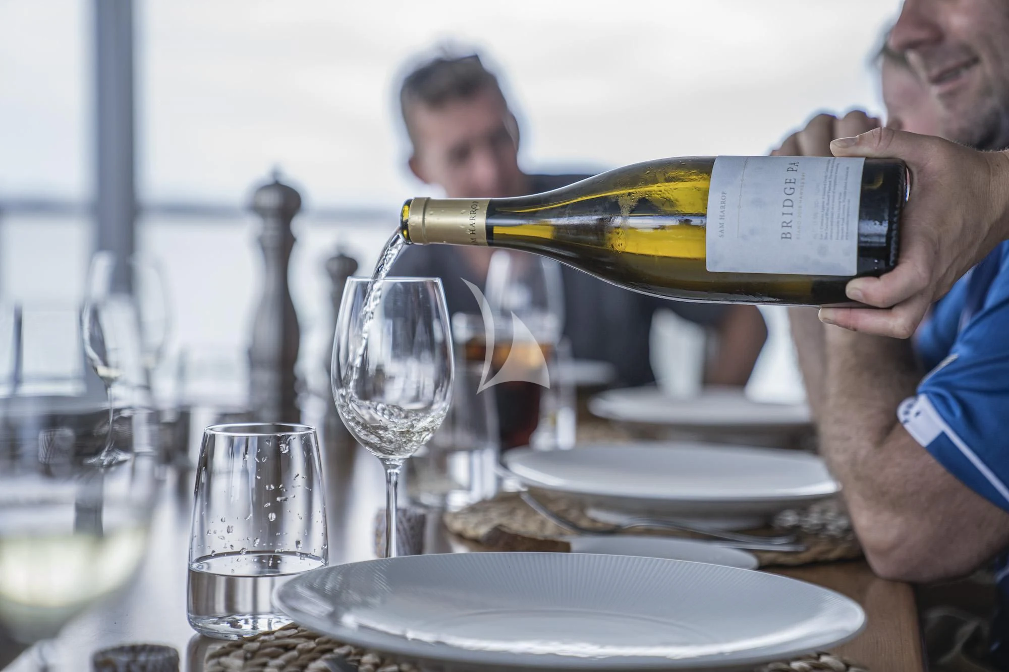 a person pouring wine into a glass aboard THE BEAST Yacht for Sale