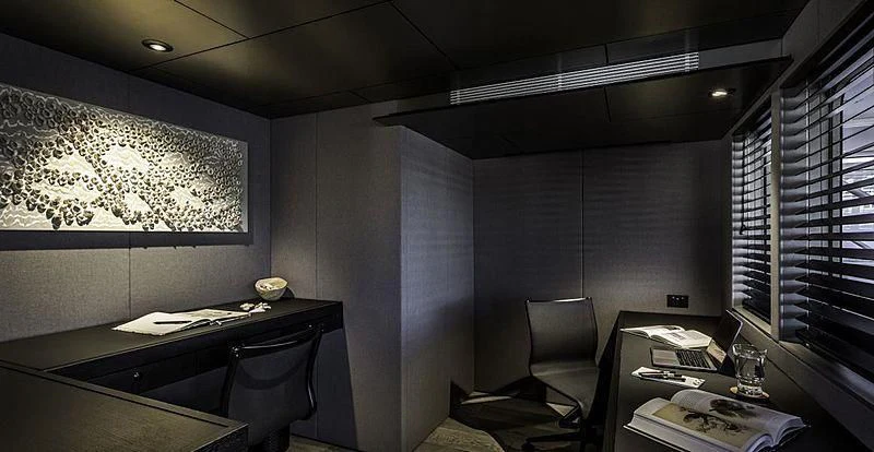 a room with a desk and chairs aboard THE BEAST Yacht for Sale