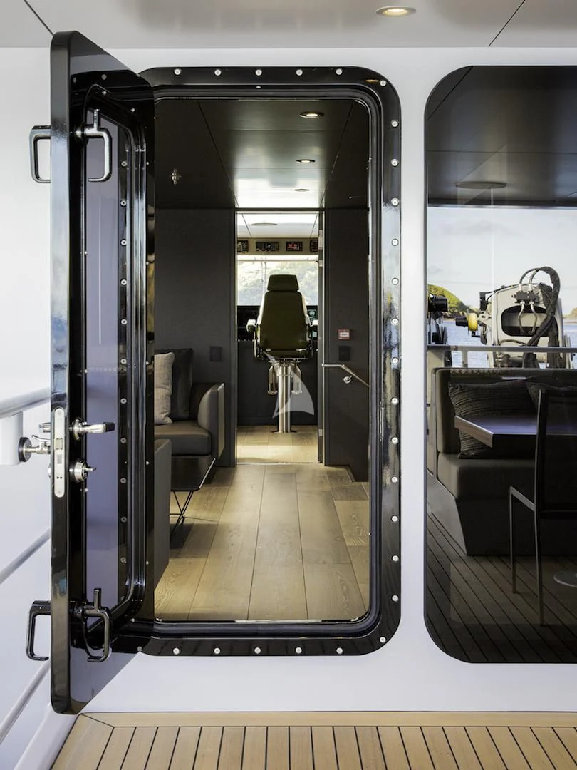 a hallway with a door and chairs aboard THE BEAST Yacht for Sale