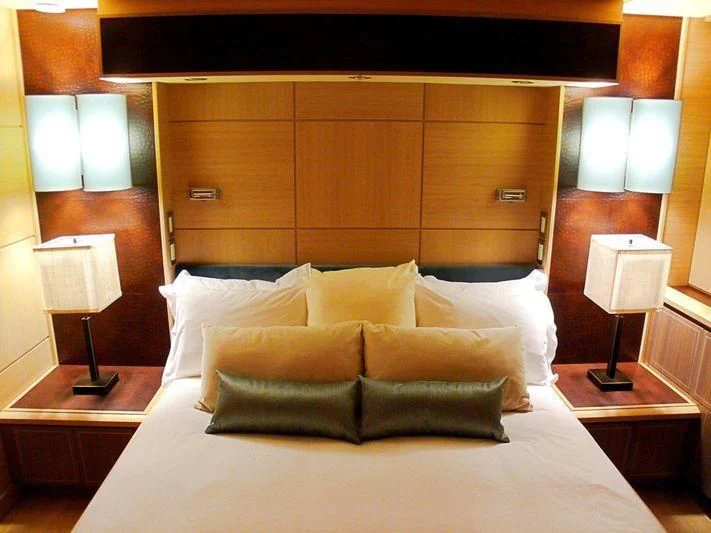 a bed with pillows and lamps aboard WAVERUNNER Yacht for Sale