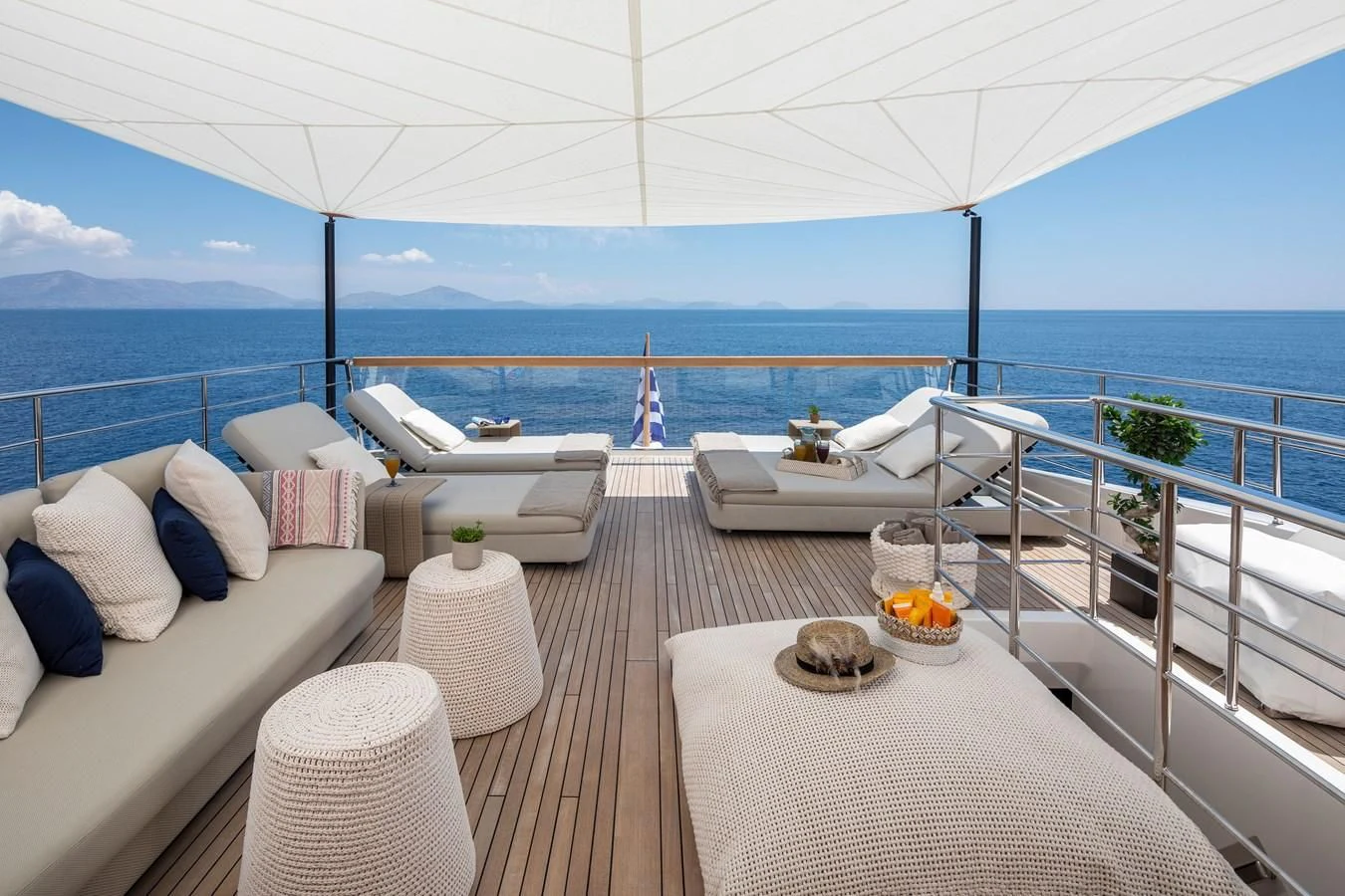 a large white lounge chair on a deck overlooking the ocean aboard DINAIA Yacht for Charter