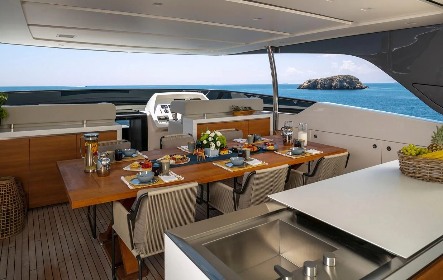 a table with chairs and a large window overlooking a beach aboard DINAIA Yacht for Charter