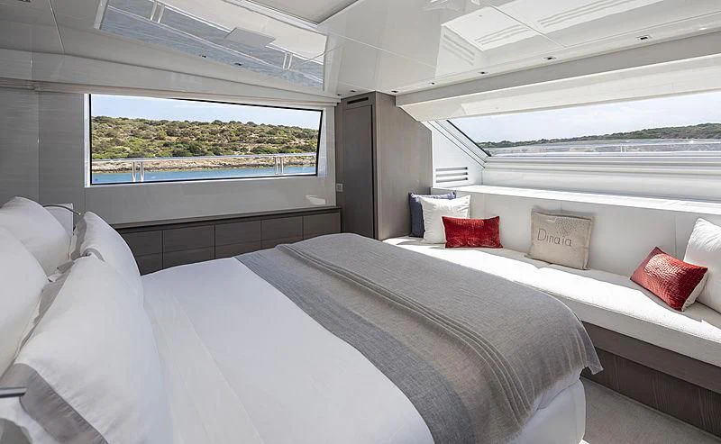 a room with a bed and pillows aboard DINAIA Yacht for Charter