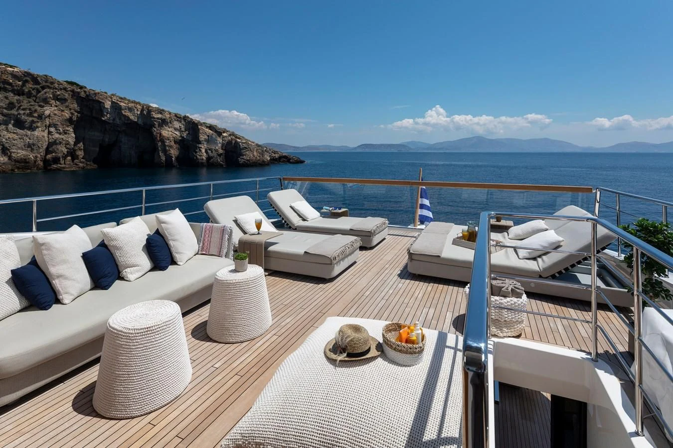 a table with chairs and a large body of water in the background aboard DINAIA Yacht for Charter