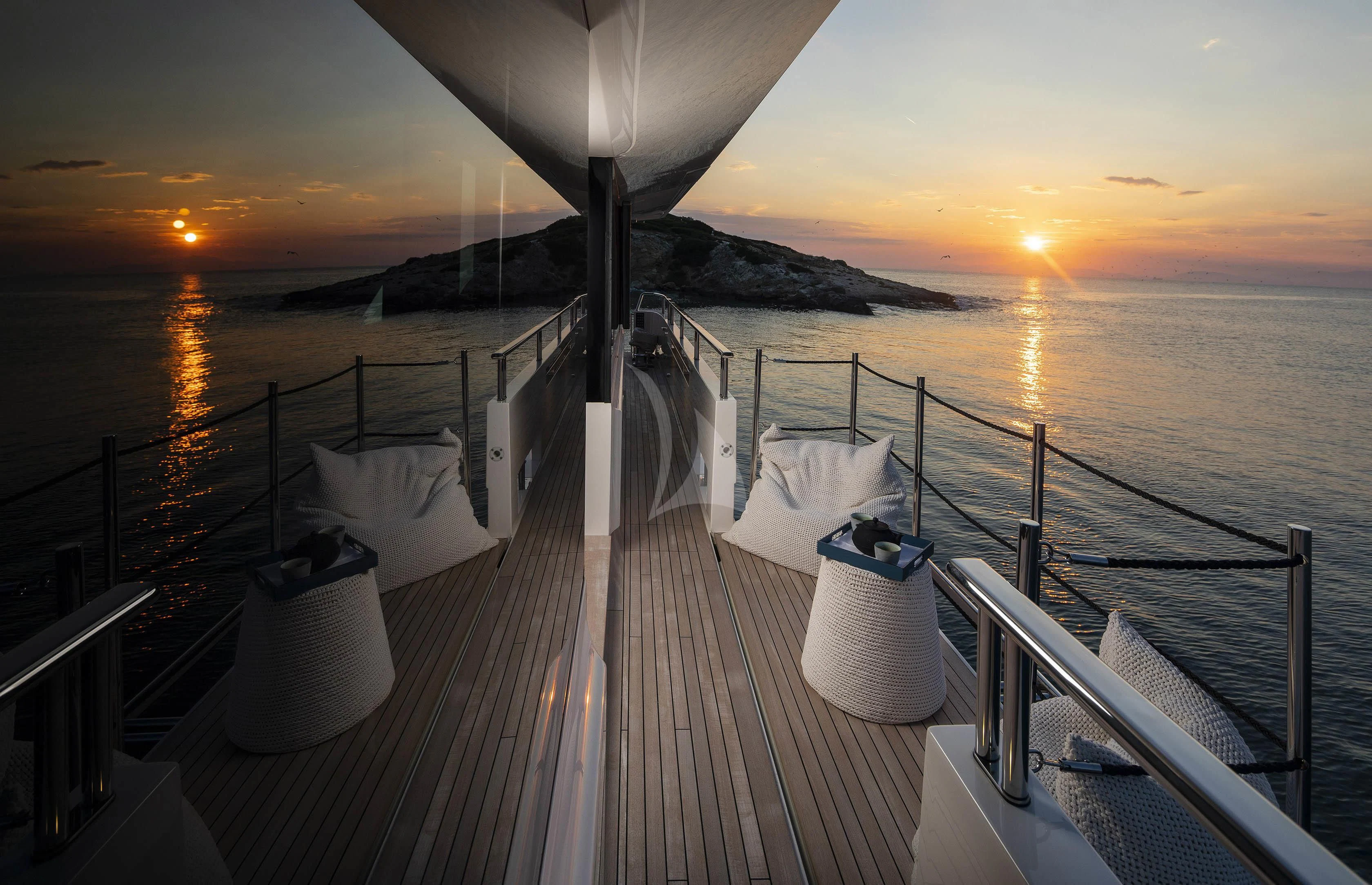 a deck with a view of the sunset and the ocean aboard DINAIA Yacht for Charter