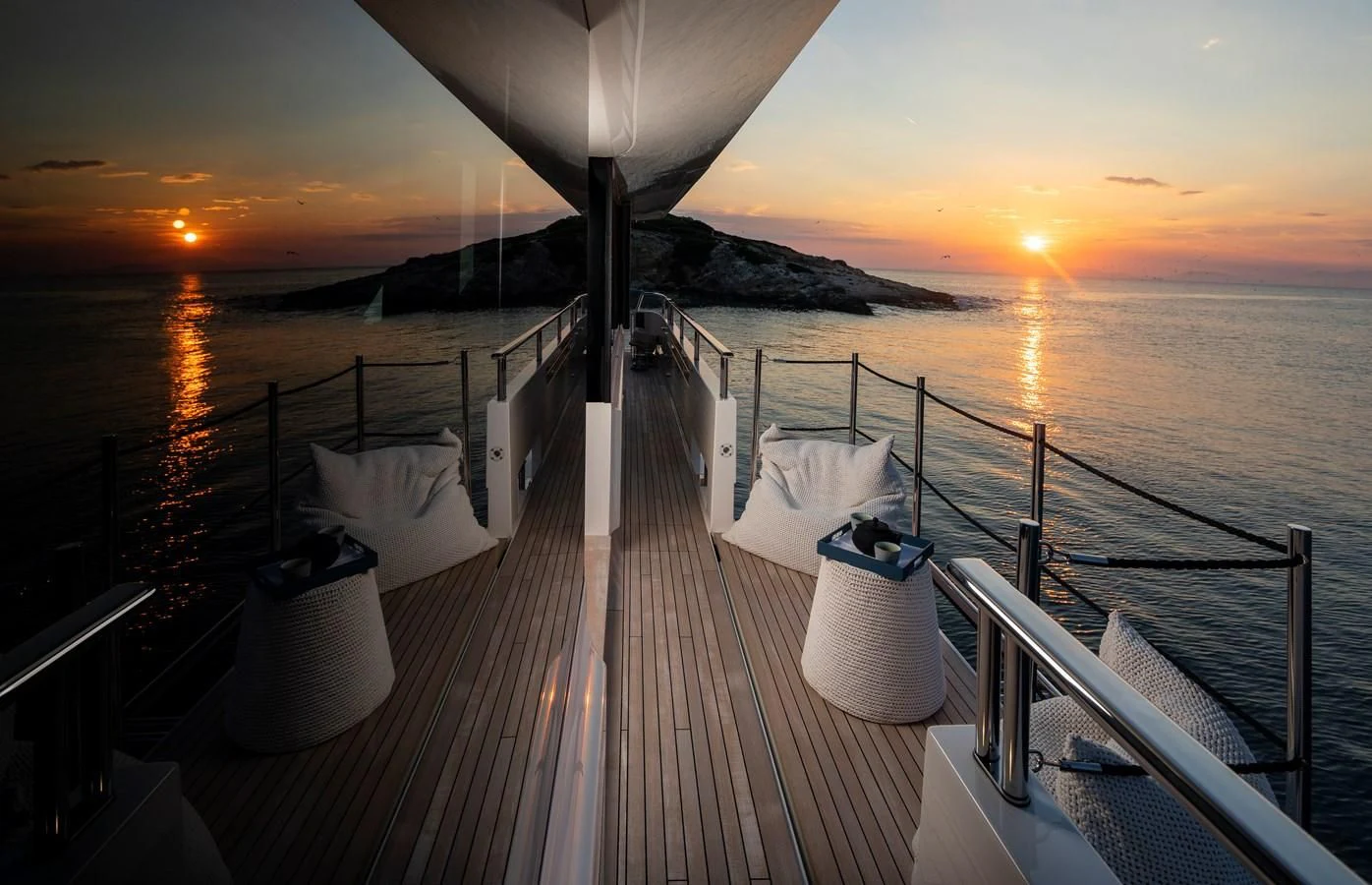 a deck with a view of the sunset and the ocean aboard DINAIA Yacht for Charter
