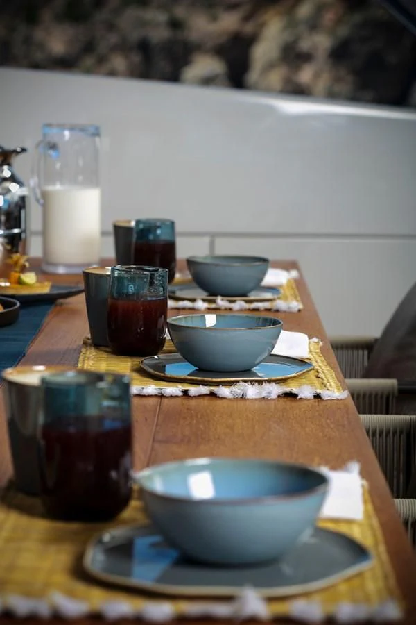 a table with a bowl and a plate of food on it aboard DINAIA Yacht for Charter