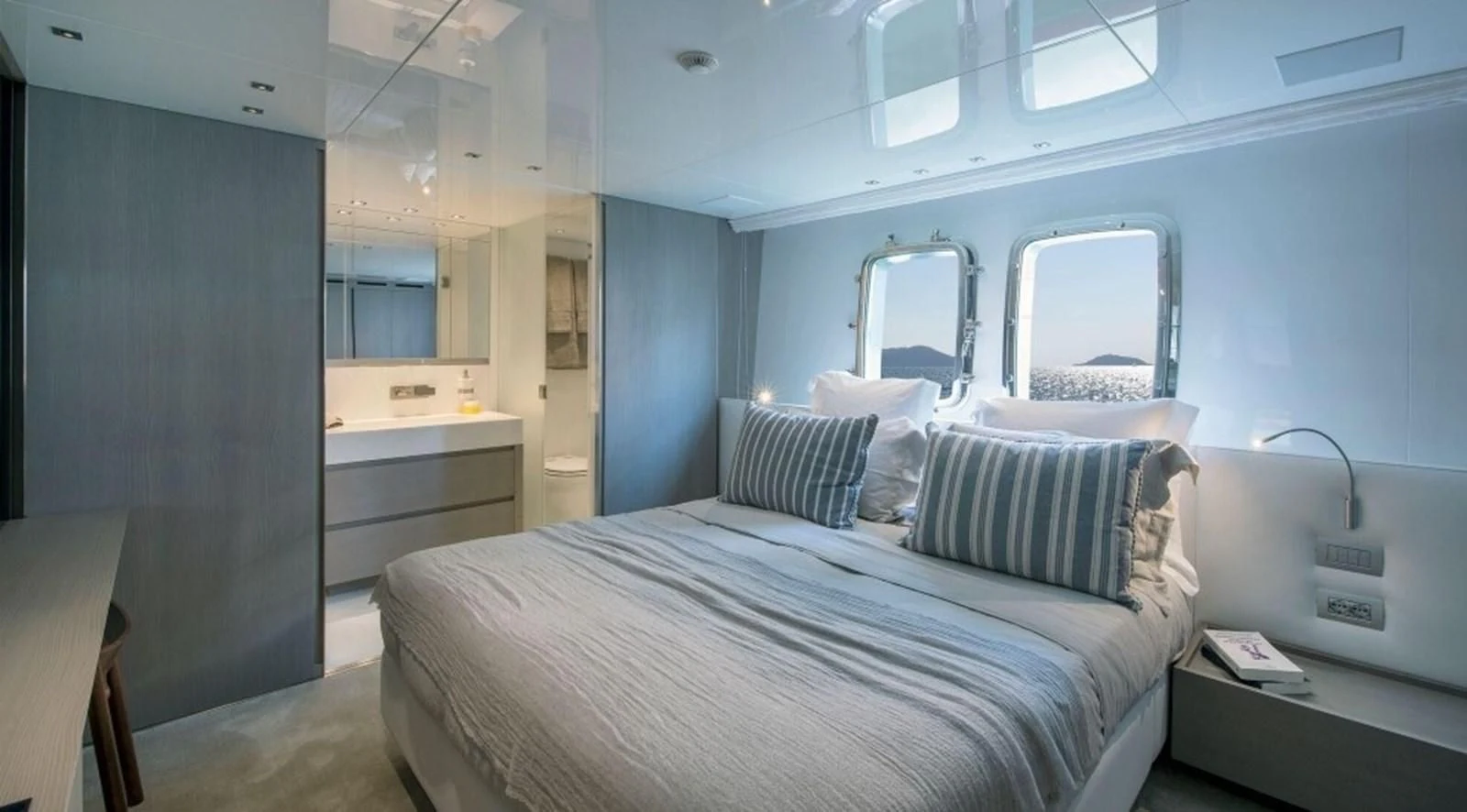 a room with a bed and a mirror aboard DINAIA Yacht for Charter