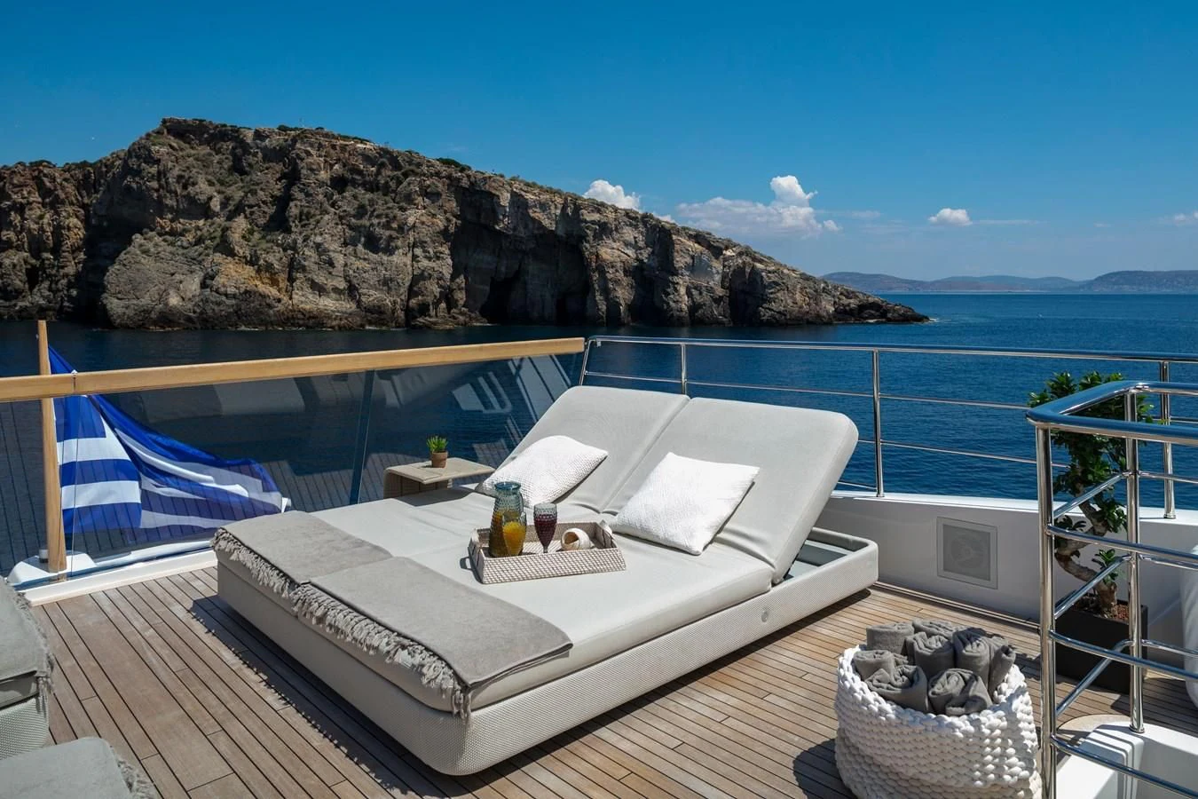 a bed on a deck overlooking a body of water aboard DINAIA Yacht for Charter