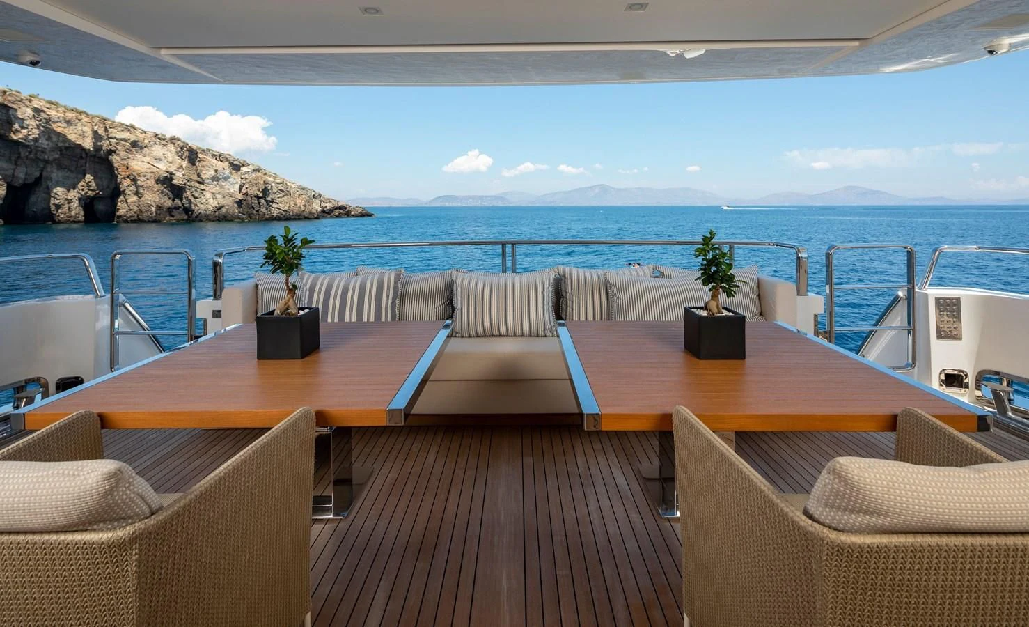 a deck with a table and chairs on it aboard DINAIA Yacht for Charter