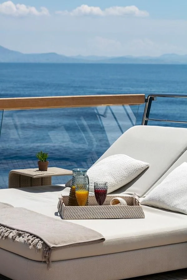 a balcony with a view of the ocean and mountains aboard DINAIA Yacht for Charter