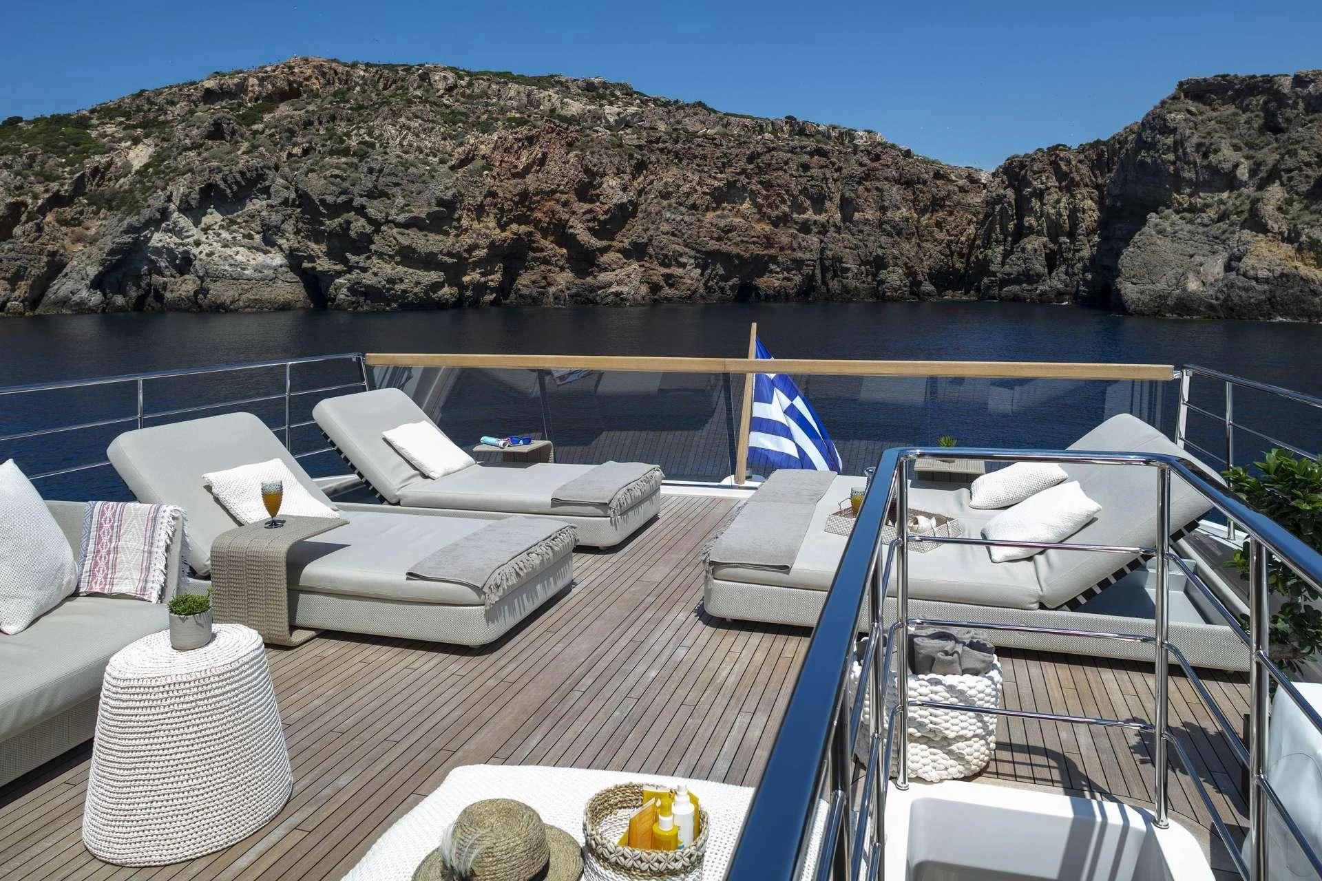 a deck with chairs and a table on it aboard DINAIA Yacht for Charter