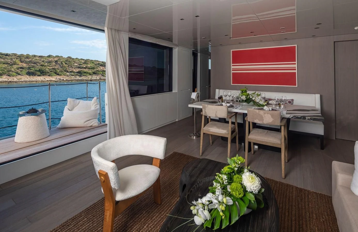 a room with a table chairs and a bed aboard DINAIA Yacht for Charter