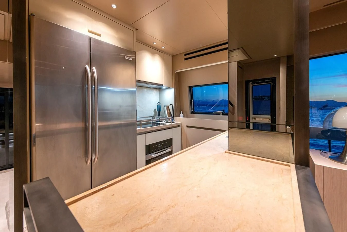 a kitchen with a large refrigerator aboard LOLA Yacht for Sale