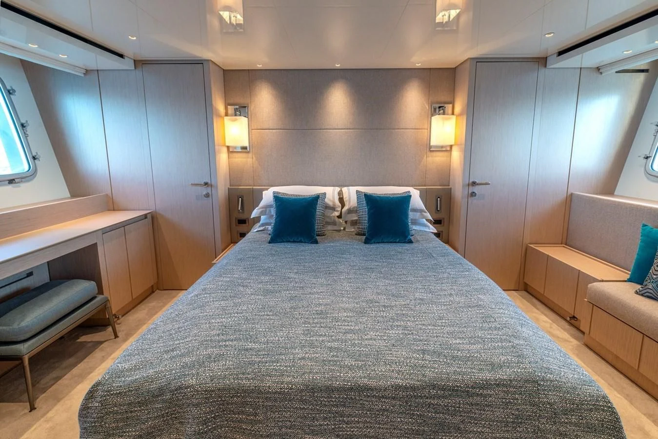 a bed with a blue comforter aboard LOLA Yacht for Sale
