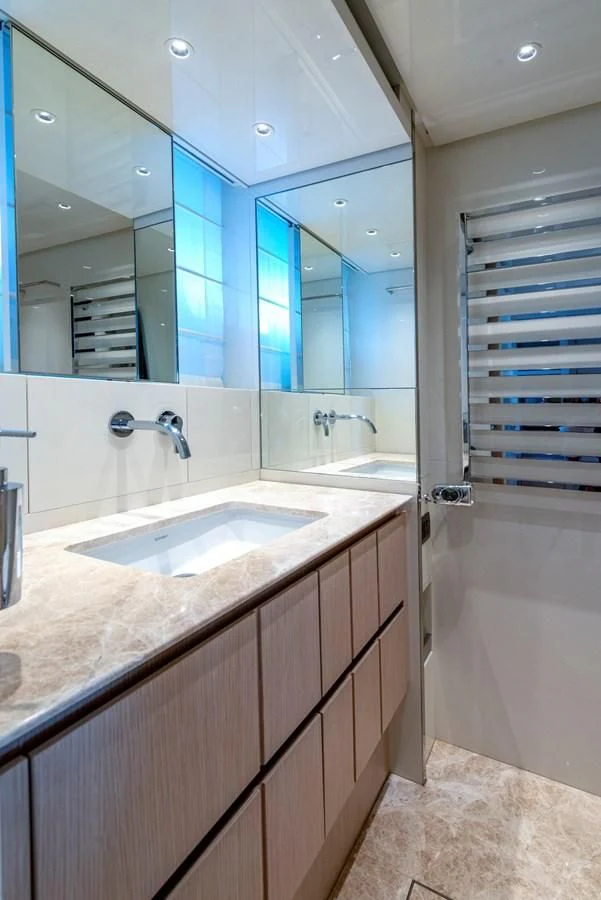 a bathroom with a countertop sink and a mirror aboard LOLA Yacht for Sale