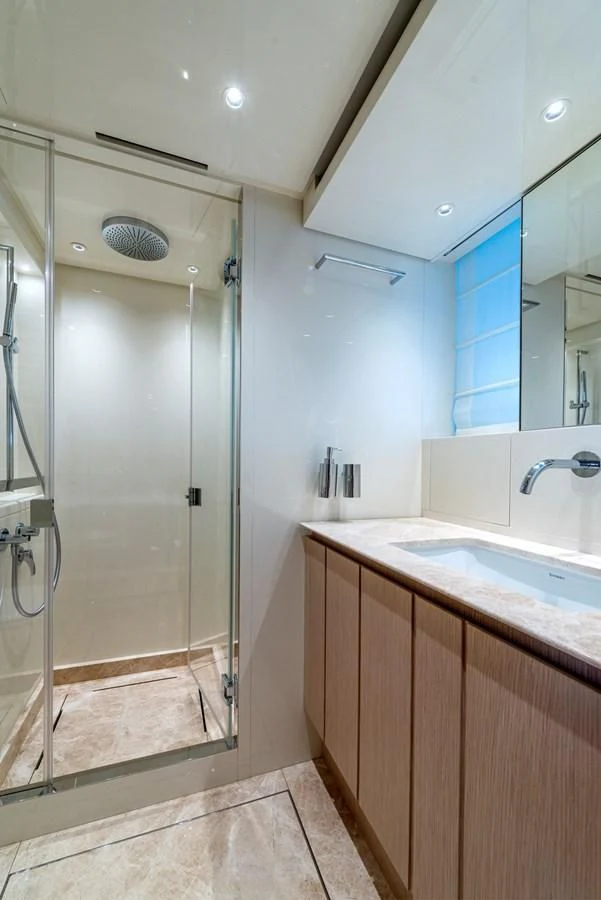 a bathroom with a glass shower aboard LOLA Yacht for Sale