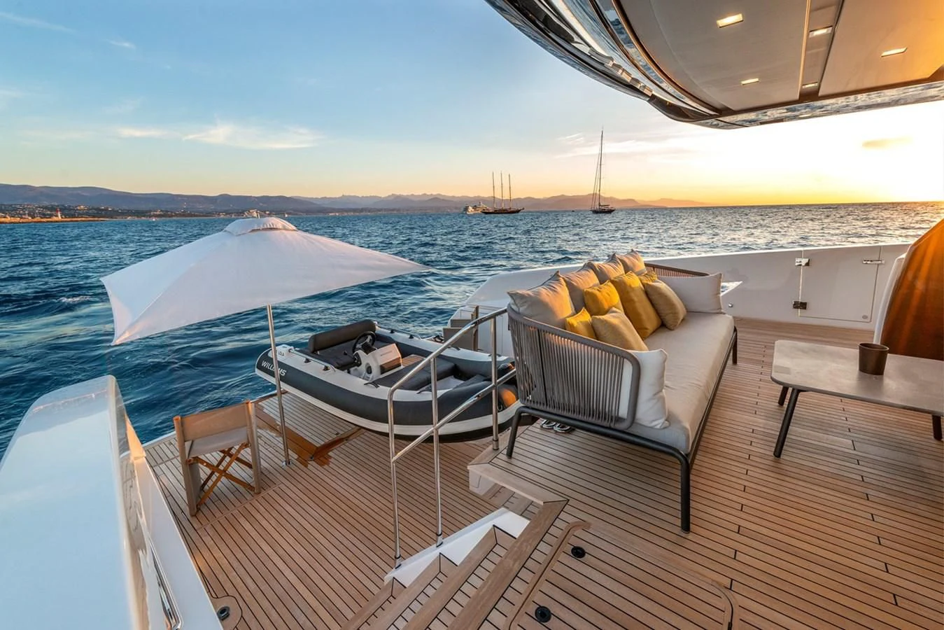 a deck with chairs and a table on it aboard LOLA Yacht for Sale