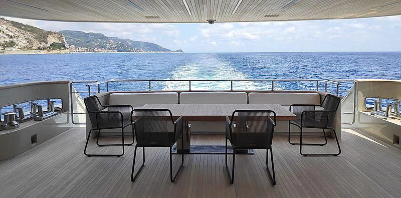 a deck with chairs and a table on it aboard CHRISTINA Yacht for Sale