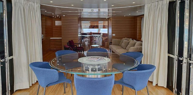 a room with a table chairs and a couch aboard CHRISTINA Yacht for Sale