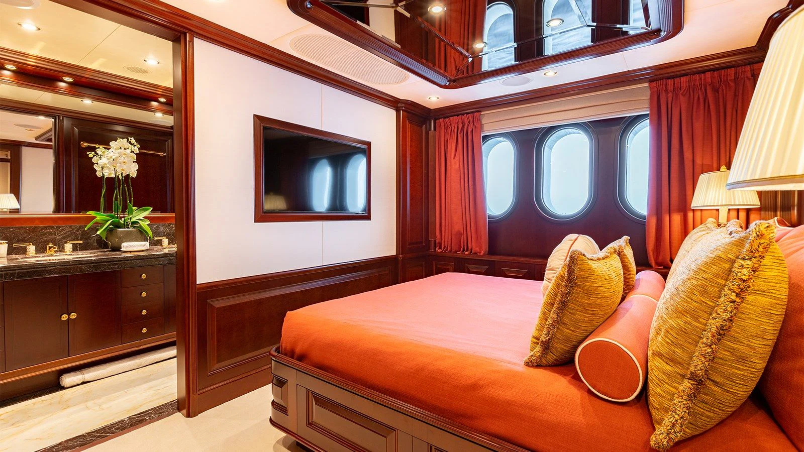 a bed with pillows and a television aboard INCAL Yacht for Sale
