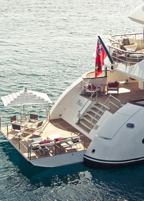 a boat with a flag on the deck aboard INCAL Yacht for Sale