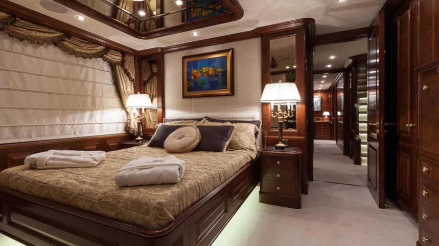a bedroom with a bed and a lamp aboard INCAL Yacht for Sale