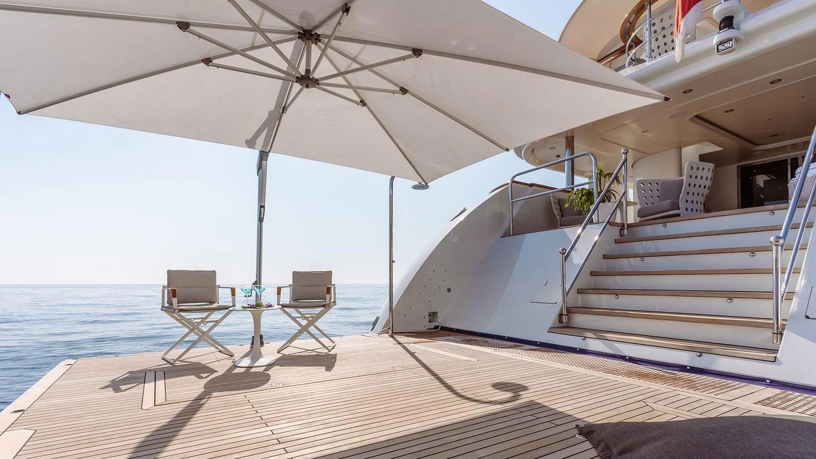 a white umbrella over a table and chairs on a deck aboard INCAL Yacht for Sale
