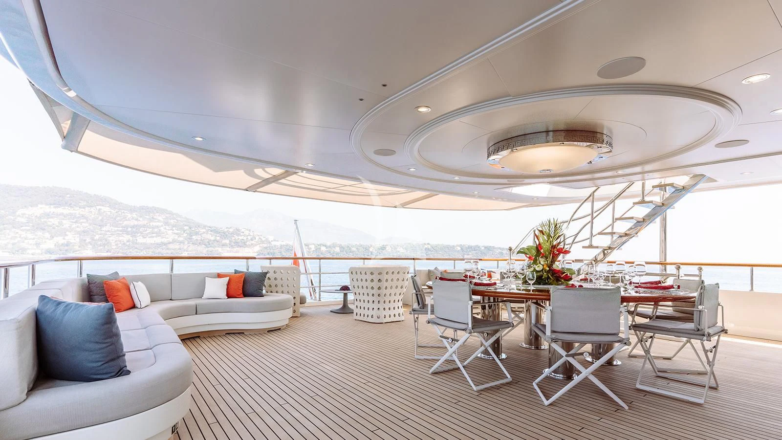 a large room with a large white tent and a table with chairs and a couch aboard INCAL Yacht for Sale