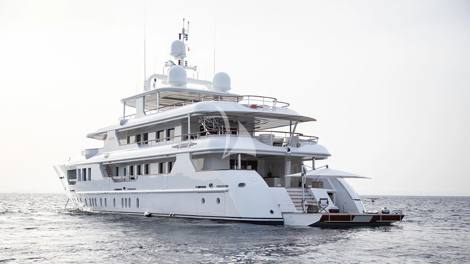 a large white boat with a smaller boat on the water aboard INCAL Yacht for Sale